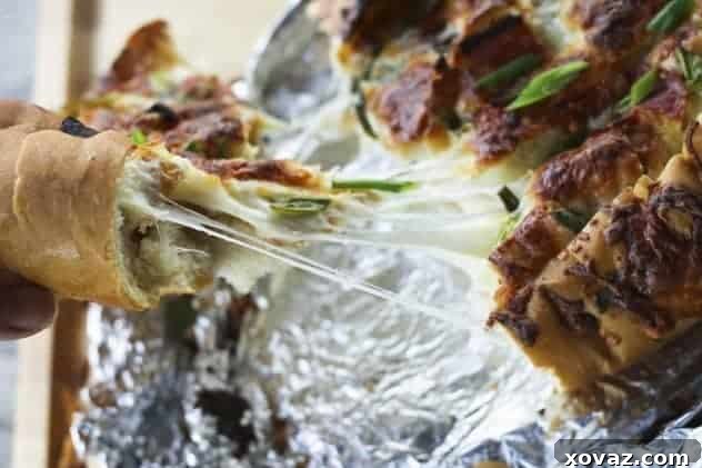 Pizza Party Bread with gooey mozzarella Close-up of Pizza Party Bread with melted mozzarella oozing from the cuts, garnished with fresh green onions.