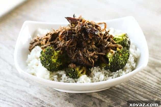 Slow Cooker Asian Beef on Broccoli - Tender shredded beef with a rich, savory, and slightly sweet Asian sauce, perfect over rice or broccoli.
