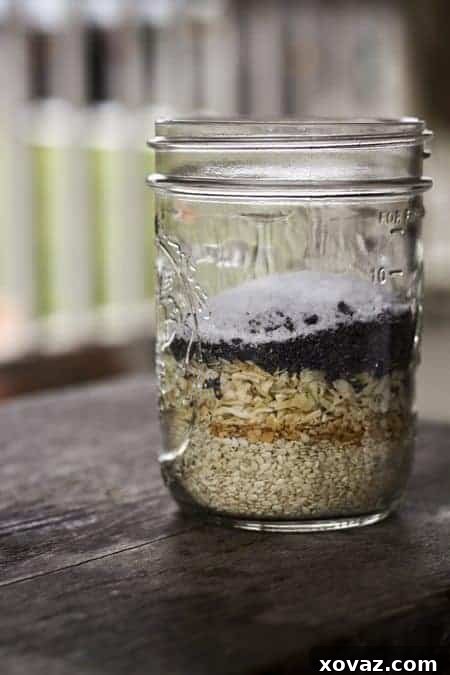 Black Russian Pumpernickel Everything Bagels 3 A batch of freshly baked Black Russian Bagels, generously coated with Everything Bagel topping, showcased on a wooden board.