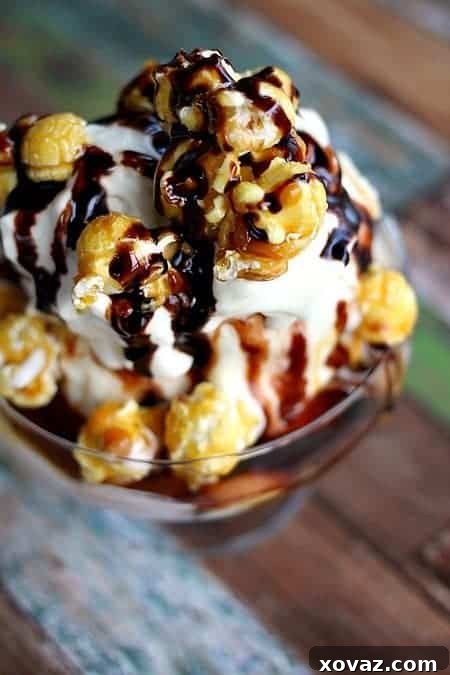 Close-up view of a luxurious Caramel Corn Ice Cream Sundae, showcasing melting hot fudge, golden caramel sauce, billowy whipped cream, and crunchy caramel corn, ready to be enjoyed