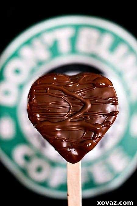 A close-up of a mocha marshmallow pop, showcasing the coffee-infused marshmallow and smooth milk chocolate coating, ready to be enjoyed.