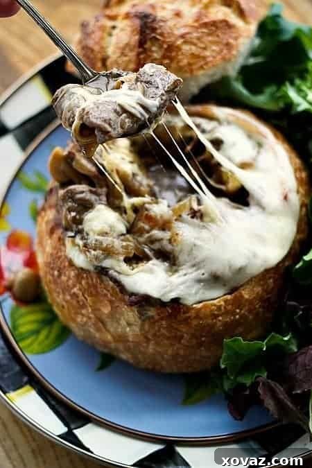 Ultimate Philly Cheesesteak Stew 4 Philly Cheesesteak Stew artfully presented in a sourdough bread bowl, garnished with melted provolone cheese and a toasted crouton.
