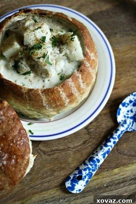Fish Chowder with Cod and Dill in a bread bowl, garnished with fresh herbs, ready to be enjoyed as a wholesome and comforting meal.
