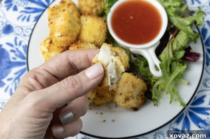 Fresh white fish fillets being cut into uniform 2-inch pieces on a cutting board, ready for breading into crispy ranch fish nuggets.