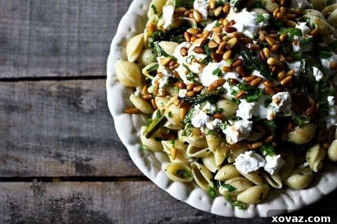 Close-up of Shells with Roasted Asparagus, Goat Cheese, and Yogurt, garnished with toasted pine nuts and chili oil, showcasing a vibrant and healthy pasta dish for spring dinners.