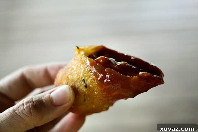 Close-up of golden Cheesy Barbecue Chicken and Bacon Eggrolls on a serving platter