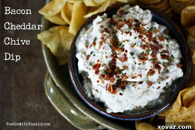 Crispy potato chips generously loaded with Bacon Cheddar Chive Dip, ready for a delicious snack.