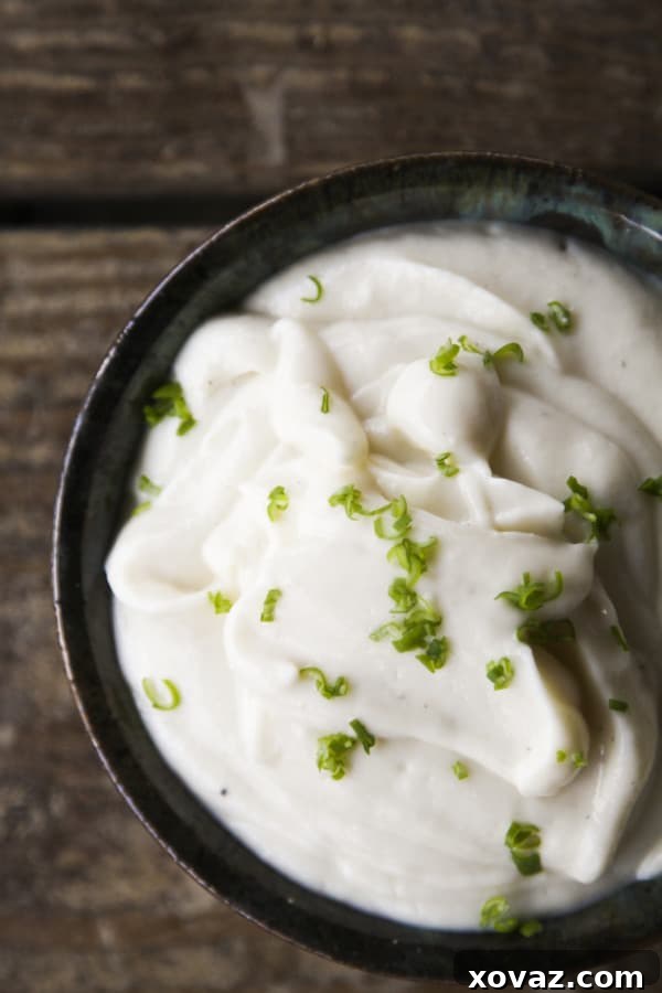 Creamy Cauliflower Delight 2 A vibrant bowl of Super silky Roasted Garlic Cauliflower Puree, garnished with fresh herbs, perfect as a versatile side dish with roast chicken, beef, or grilled meats.