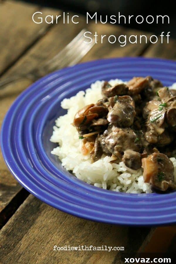 A close-up of a rich, intensely garlicky, and creamy Garlic Mushroom Stroganoff, served over fluffy rice, showcasing its tender, meaty mushrooms and vibrant parsley garnish.