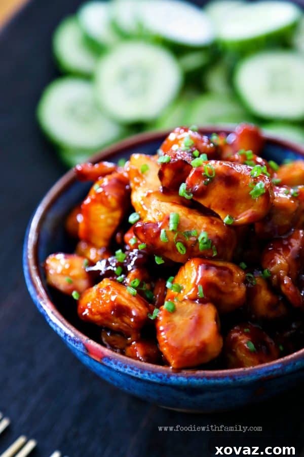 Perfectly cooked Honey Sriracha Glazed Chicken Bites garnished with fresh chives, ready to serve