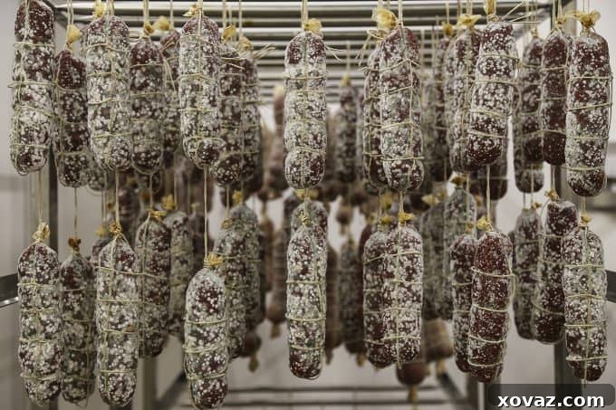 Signor Falaschi, a revered producer of traditional Italian prosciutto, welcoming visitors to his facility.