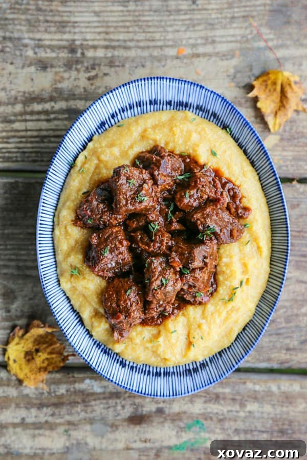 Peposo: Tuscany's Peppery Braised Beef 2 Tuscan Braised Beef in red wine sauce on creamy polenta in a blue and white dish.