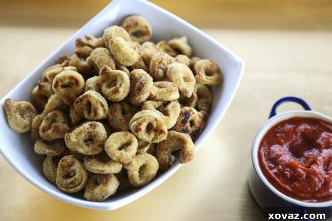 Golden brown Toasted Tortellini Bites arranged on a platter, ready to be served with marinara sauce.