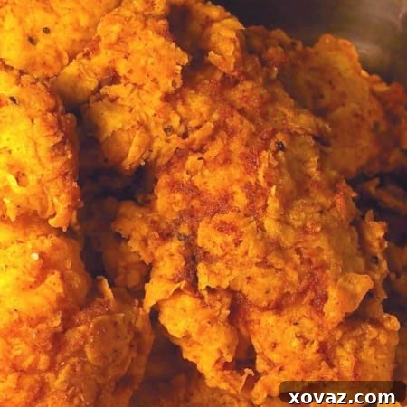 Golden Crispy Chicken Tenders 2 A close-up view of freshly made extra crispy fried chicken fingers, showcasing their golden-brown color and crunchy texture.