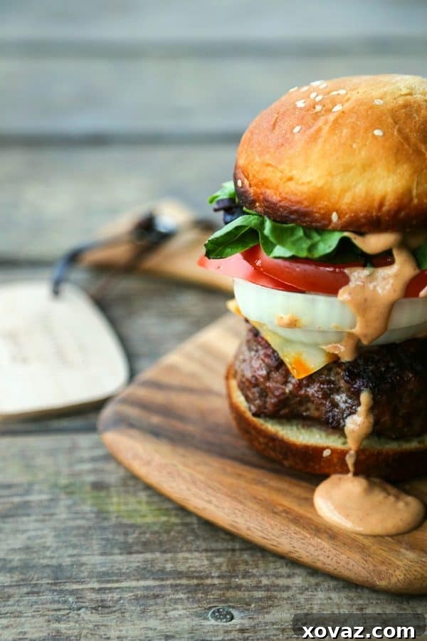 The Ultimate Burger Condiment 2 Homemade Burger Sauce from Foodie with Family, showing a generous dollop of creamy pink sauce on a burger patty with lettuce and cheese.