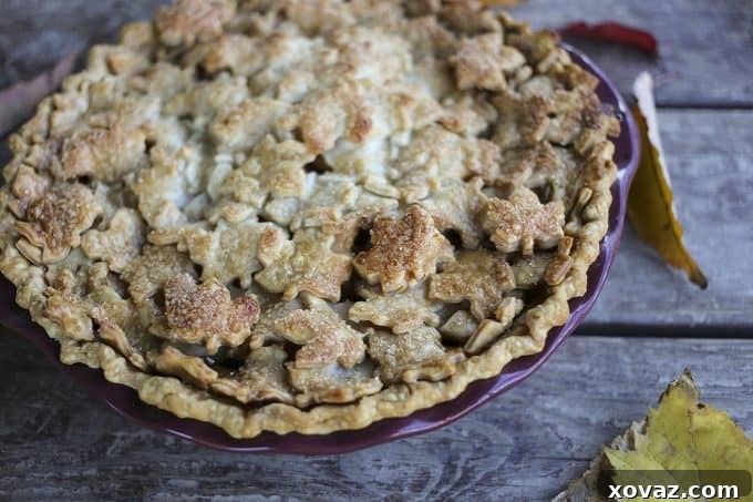 Chai-Spiced Maple Apple Pie 5 A freshly baked Maple Chai Apple Pie on a cooling rack, steam gently rising from the gaps in its elegant, tiled crust.