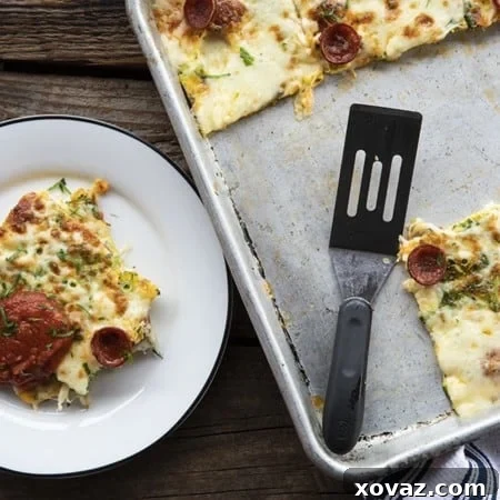 A perfectly baked Pizza Frittata, golden brown with melted mozzarella and crispy pepperoni, served on a white plate. A garnish of fresh parsley adds a touch of color, inviting you to savor this comforting dish.