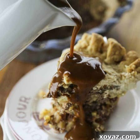 Meat and Potatoes Pie: a golden, flaky butter crust generously filled with savory beef, potatoes, and root vegetables, served with a side of rich brown gravy for a truly comforting meal.