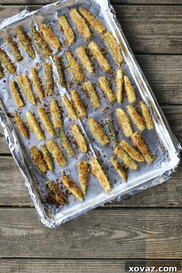 A close-up of Crispy Baked Parmesan Zucchini Fries on a rustic serving board, showcasing their appealing golden texture, perfect as a snack or appetizer.