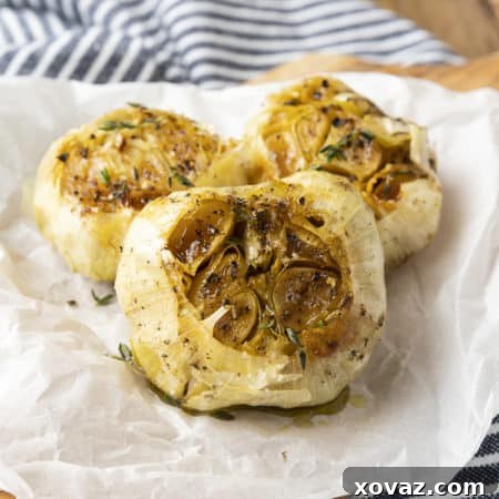 Delicious oven-roasted garlic cloves, soft and caramelized, ready to be squeezed out for use in various dishes.