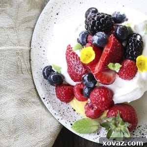 Ethereally light, crisp on the outside, marshmallowy on the inside, this Mini Pavlova Recipe is topped with lemon curd, berries, whipped cream, and ready for summer!