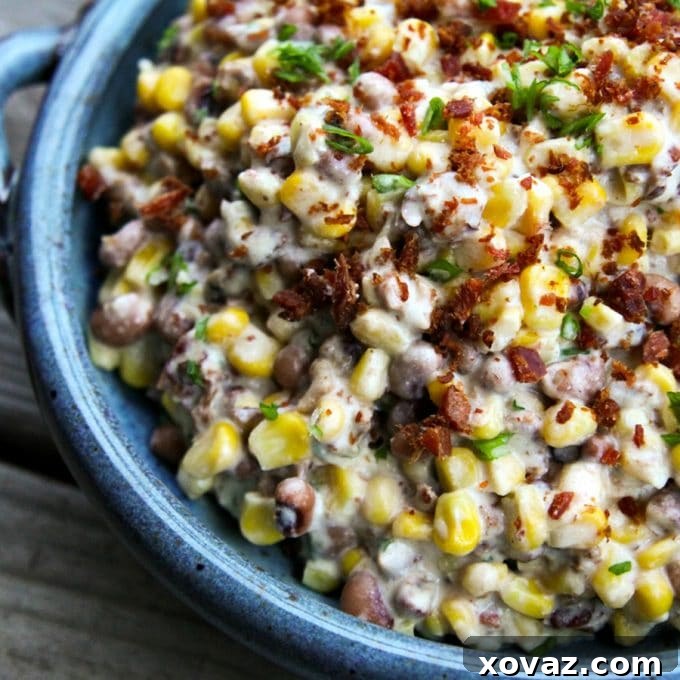 Beyond the Cob: The Astonishing Uses of Corn 2 Hearty slow-cooker black-eyed pea dip with corn and bacon, garnished with green onions and crumbled bacon, served in a rustic blue bowl.