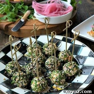A vibrant platter of mini cheese balls, each rolled in chives and everything bagel seasoning, ready to be served.