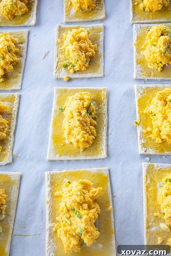 Golden Cheesy Egg and Sausage Breakfast Pockets 3 Close-up of the delicious filling for Breakfast Hot Pockets, showing cheesy scrambled eggs with green onions and cooked sausage links.