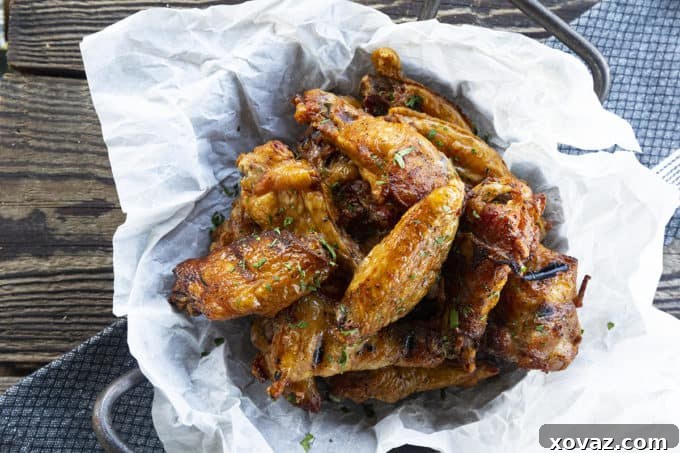 Smoky Crispy Chicken Wings 3 A close-up shot of perfectly smoked chicken wings glistening with flavor on a grill grate.