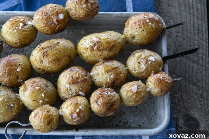 Smoky Grilled Potatoes 4 A mix of grilled potato chunks, seasoned with herbs, piled on a serving plate.