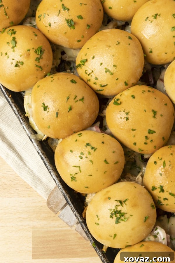 Freshly baked BBQ Chicken Sliders on a sheet pan, showcasing golden-brown rolls, saucy pulled chicken, melted provolone cheese, and vibrant pickled red onions. Perfect for easy weeknight meals or game day recipes.