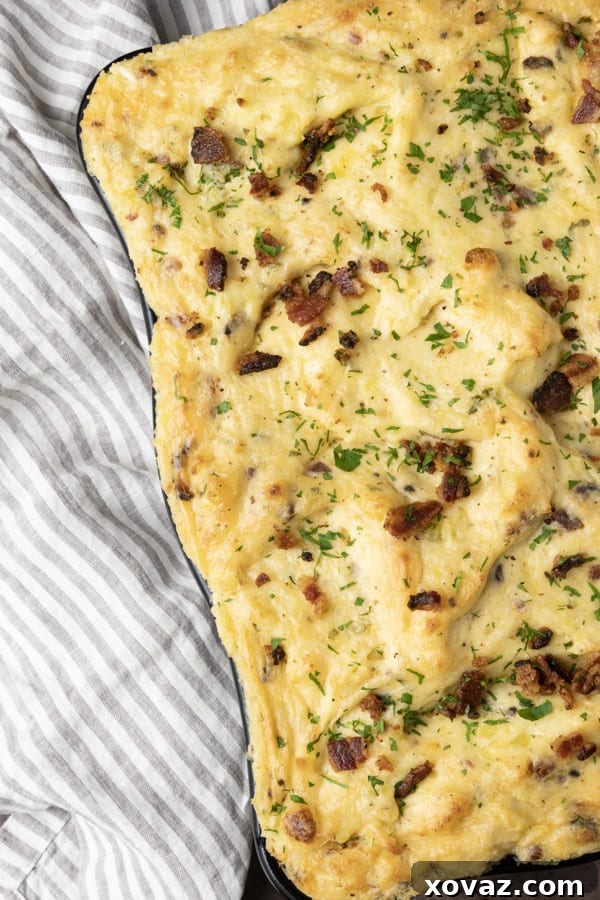 Close-up of the creamy texture and golden top of Twice Baked Mashed Potatoes in a casserole dish.