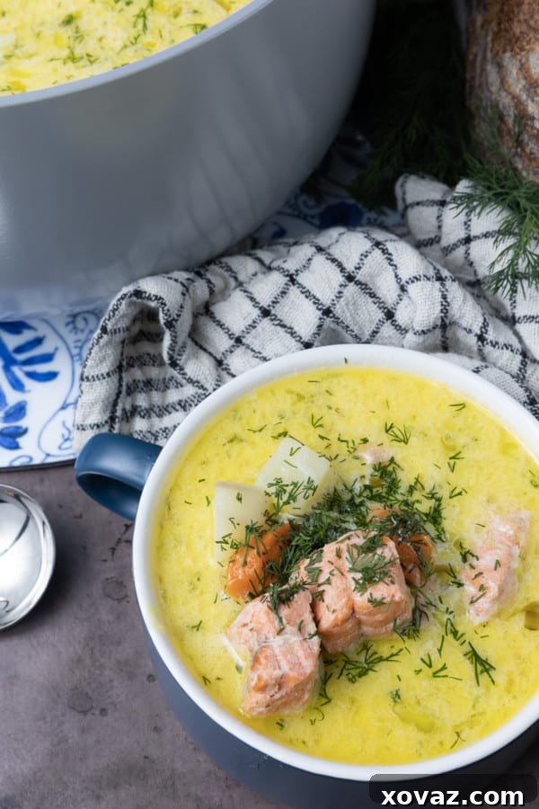 Ingredients for Finnish Salmon Soup laid out on a cutting board, including fresh salmon, leeks, potatoes, and dill.