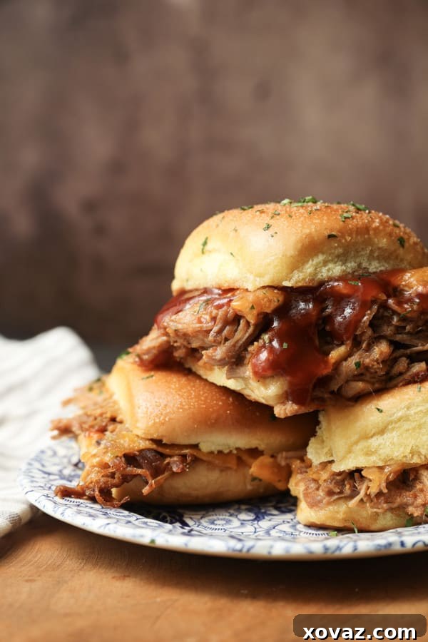 Smoky Pulled Pork Mini Sandwiches 2 Easy Pulled Pork Sliders on a baking sheet, ready to be served, topped with fresh herbs.
