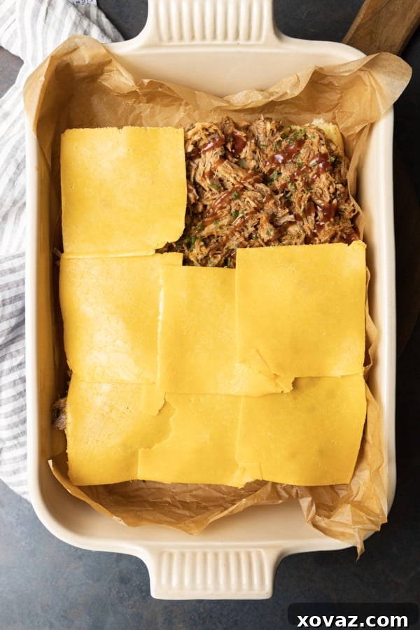 Smoky Pulled Pork Mini Sandwiches 5 The top half of slider buns, brushed with melted garlic butter and herbs, placed over the cheesy pork filling.