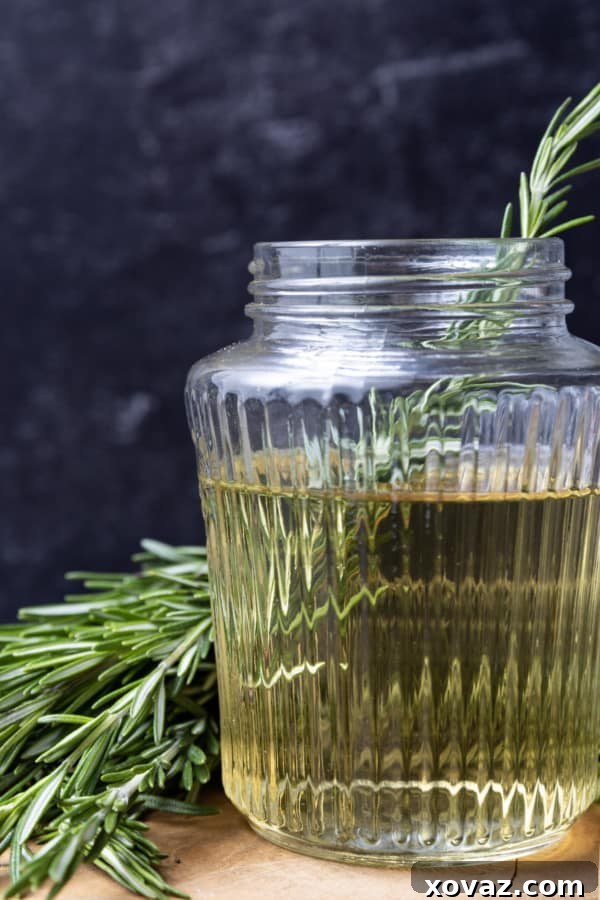 Rosemary Infused Syrup 2 A close-up of fresh rosemary sprigs steeping in a clear simple syrup, showcasing the herbal infusion.
