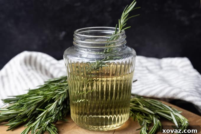 Rosemary Infused Syrup 5 A hand gently smacking fresh rosemary sprigs on a wooden cutting board with the back of a knife.