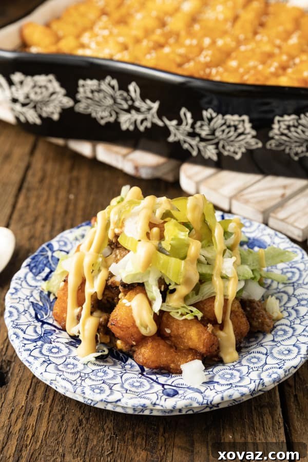 Big Mac Tater Tot Casserole: A delicious blend of seasoned ground beef, melty cheese, and crispy tater tots, baked to perfection. Served with classic burger toppings like shredded lettuce, diced onions, and pickles, drizzled with special sauce.