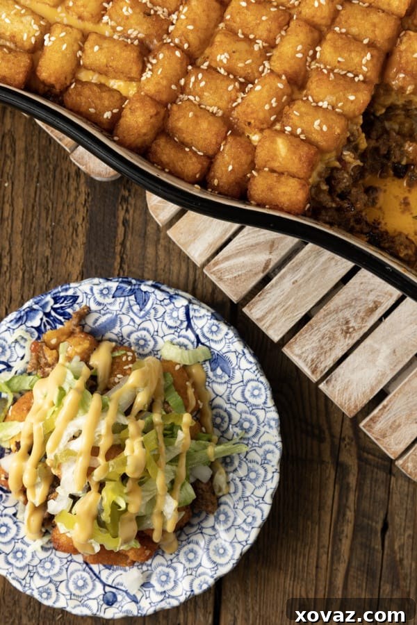 Close-up of Big Mac Tater Tot Casserole, showcasing the bubbly, cheesy ground beef base and golden, crispy tater tot topping.