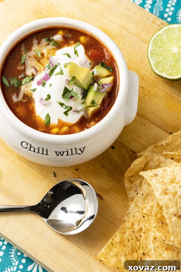 Easy 5-Ingredient Taco Soup 2 A vibrant bowl of 5-Ingredient Taco Soup garnished with fresh cilantro, a dollop of sour cream, and crispy tortilla chips, photographed from above.