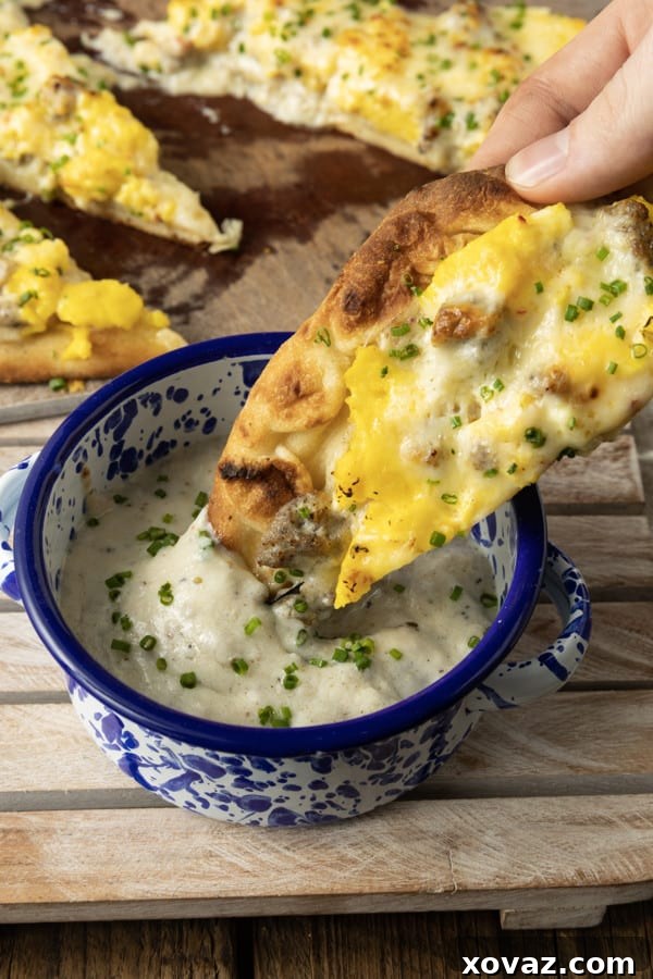 Fluffy scrambled eggs, lightly cooked and still moist, being stirred in a non-stick skillet before adding cheese for the breakfast pizza.