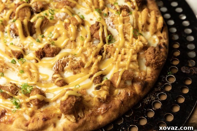 A perfectly baked pan pizza with a golden crust and bubbly cheese, fresh from the oven.