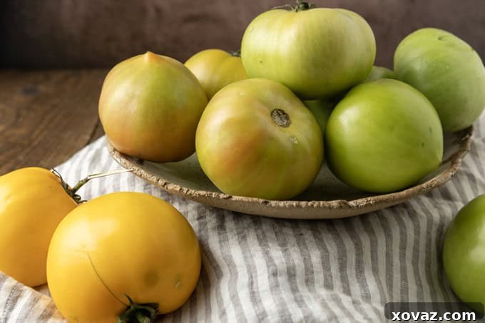 Crispy Air Fryer Fried Green Tomatoes 4 green tomatoes in a pottery bowl with a taupe and white striped linen