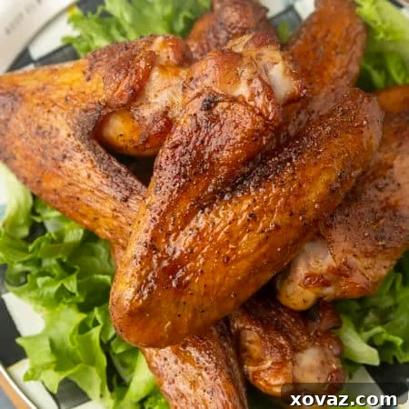 Smoked turkey wings on top of a black and white checked plate with lettuce