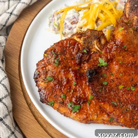 thin cut pork chop cooked in the air fryer on a plate with potato salad