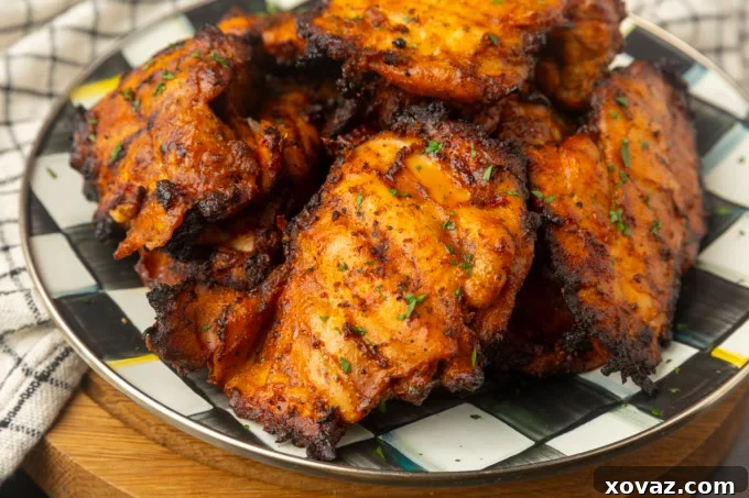 Perfect Pellet Grilled Chicken Thighs 3 Close-up of golden-brown chicken thighs arranged on a pellet grill grate, showcasing their crispy skin.