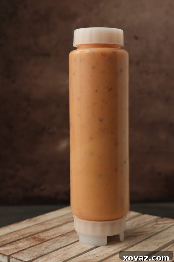 Irresistible Bang Bang Sauce 4 A person pouring sauce into a FIFO bottle using a funnel.