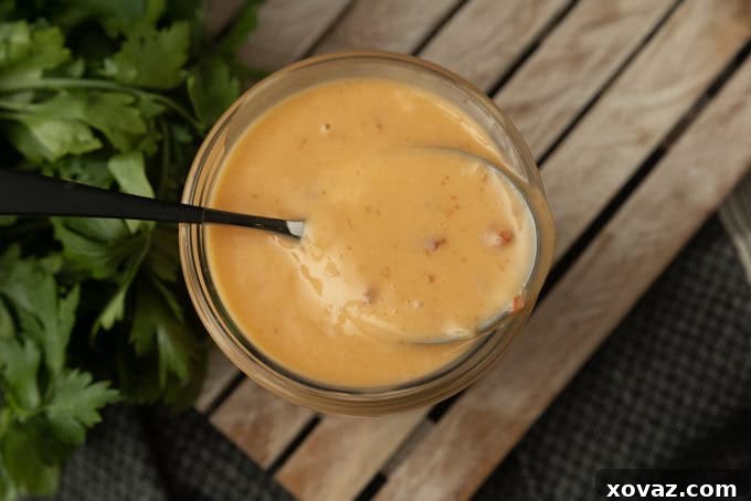 Irresistible Bang Bang Sauce 5 Bang Bang Sauce in a glass jar with a spoon, ready for serving