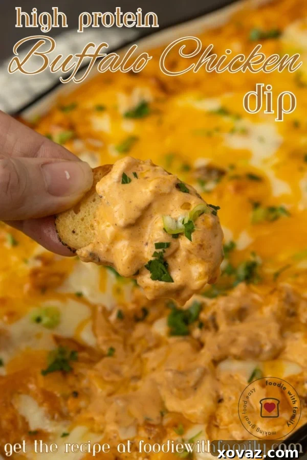 A hand holding a piece of buffalo chicken dip.