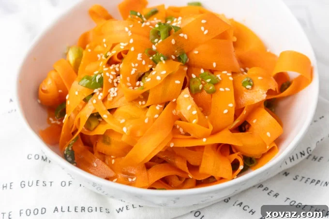 Close-up of carrot ribbon salad in a white bowl, showcasing the delicate ribbons